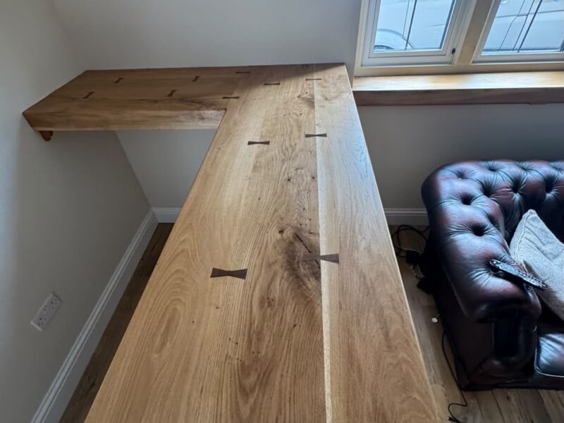 L-shaped solid oak bar top with visible grain and butterfly joints