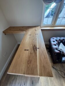 L-shaped solid oak bar top with visible grain and butterfly joints